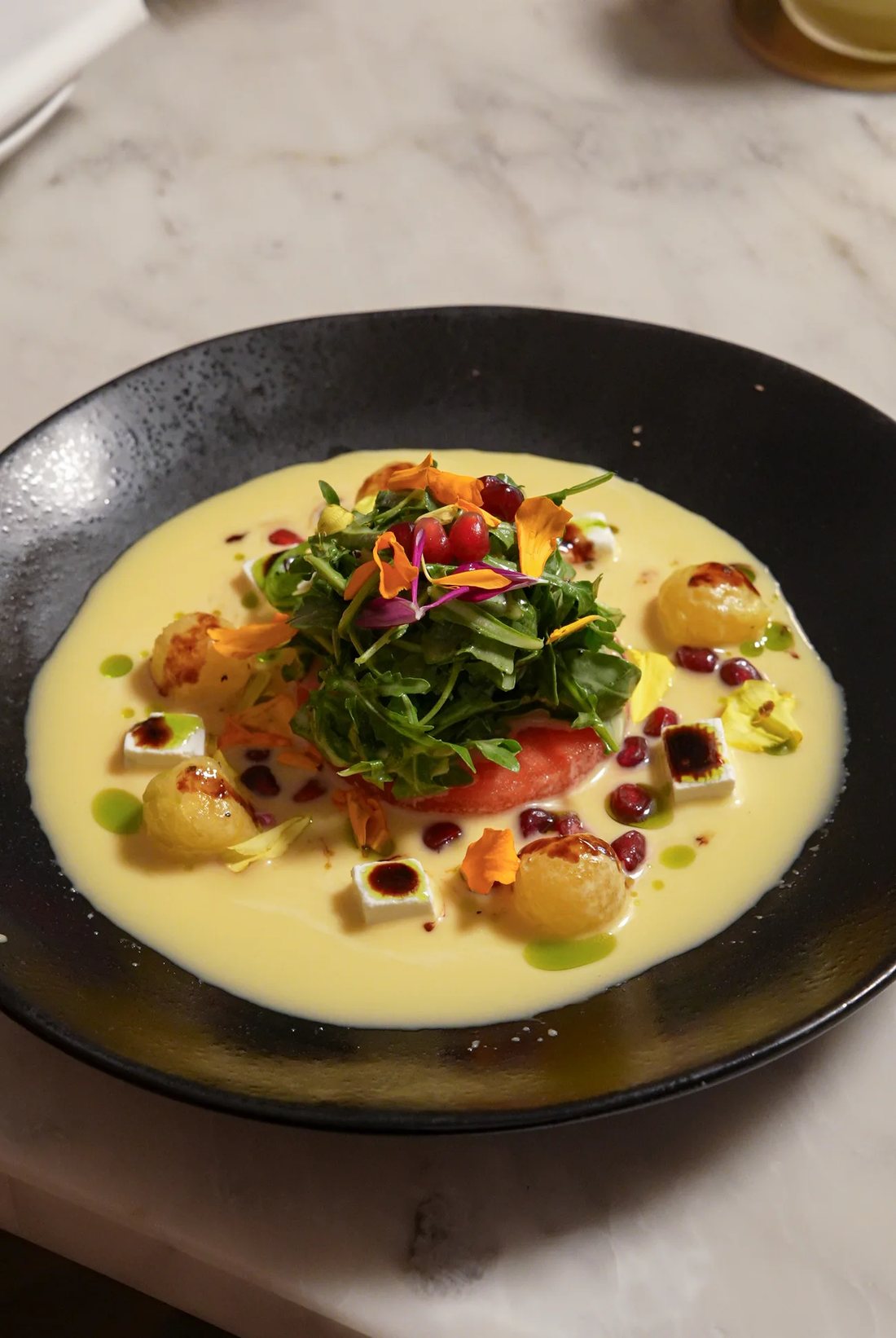 Seasonal plate with arugula, pomegranate and edible flowers